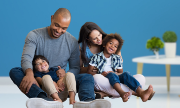 Family sits on floor smiling